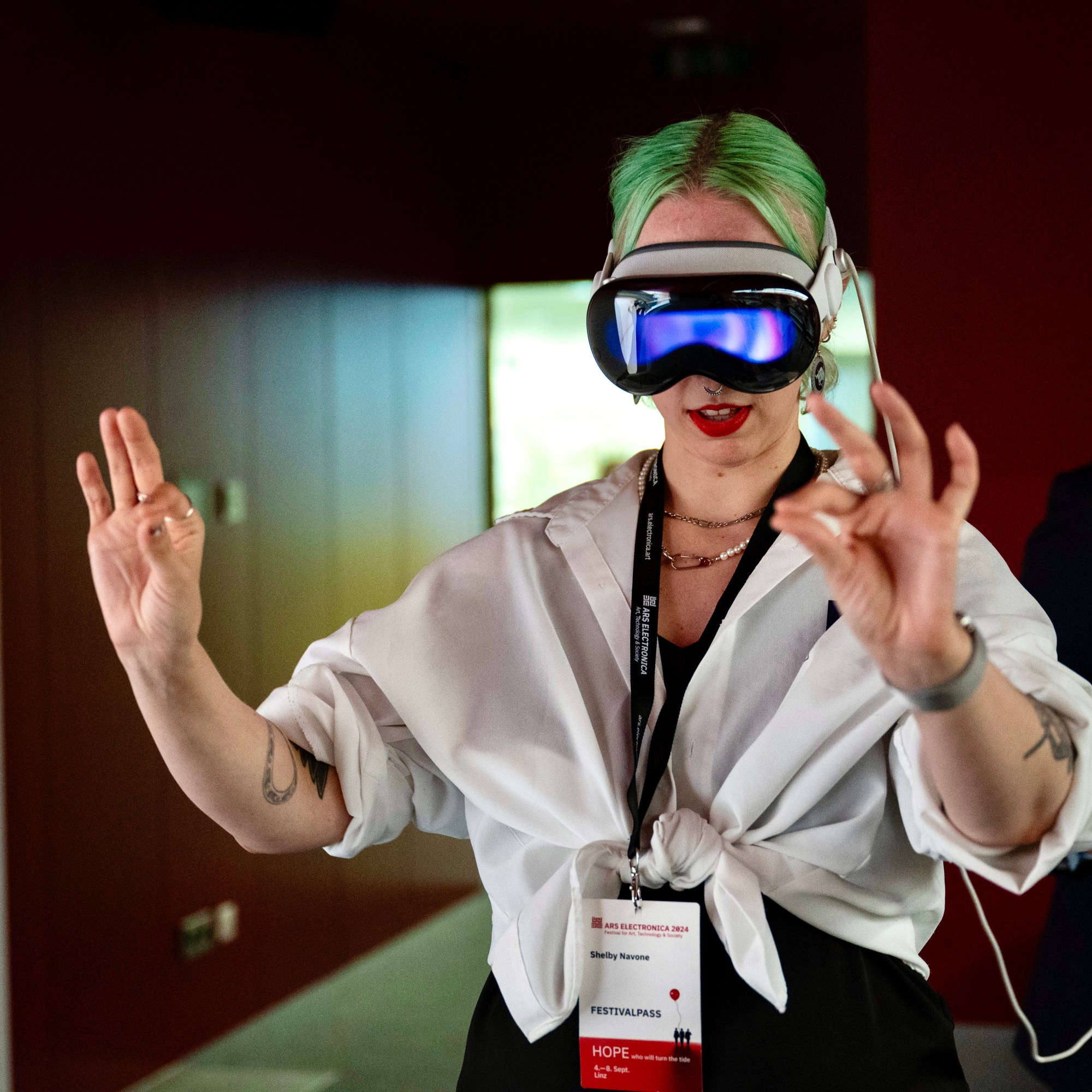 White woman with green hair wears a virtual reality headset