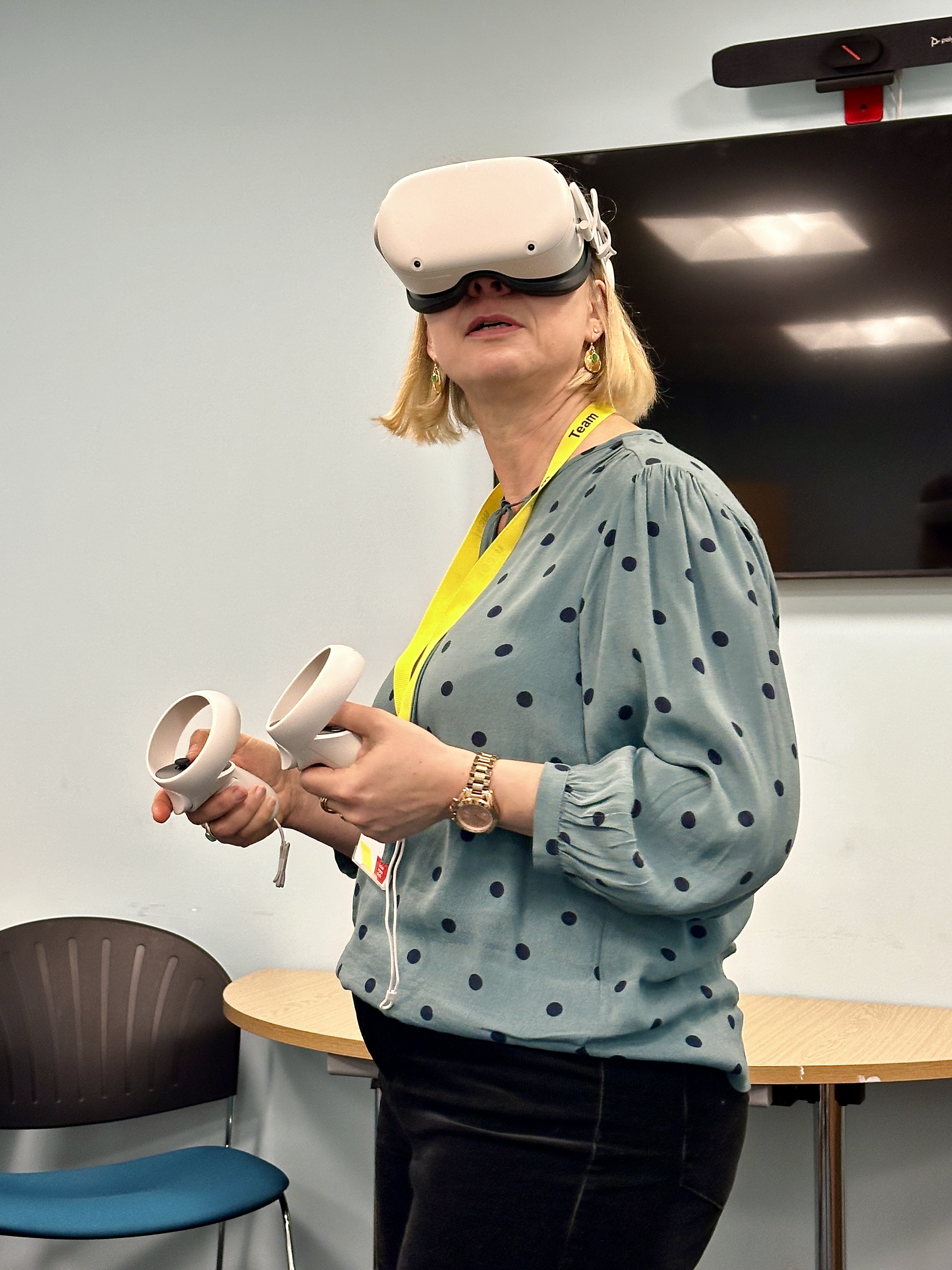 A blonde white woman wears a VR headset